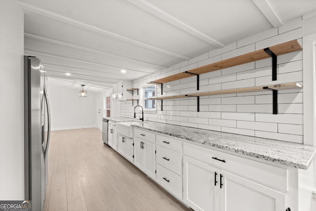 kitchen featuring white cabinetry, sink, stainless steel appliances, light stone counters, and light wood-type flooring