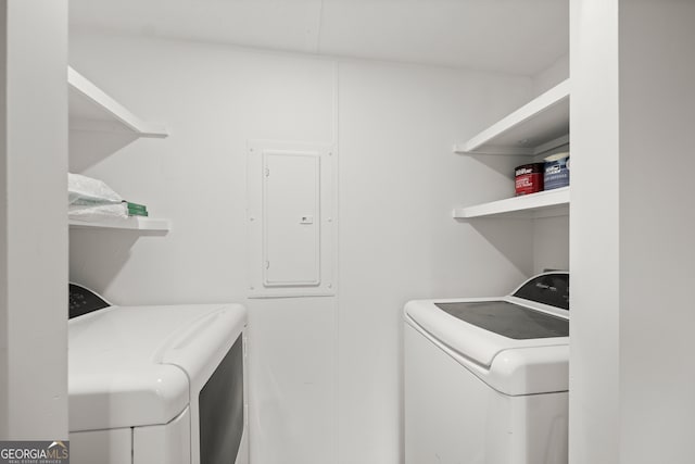 laundry room with electric panel and washer and clothes dryer