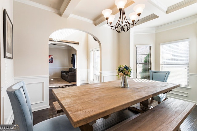 dining space featuring beam ceiling, a notable chandelier, dark hardwood / wood-style floors, and ornamental molding