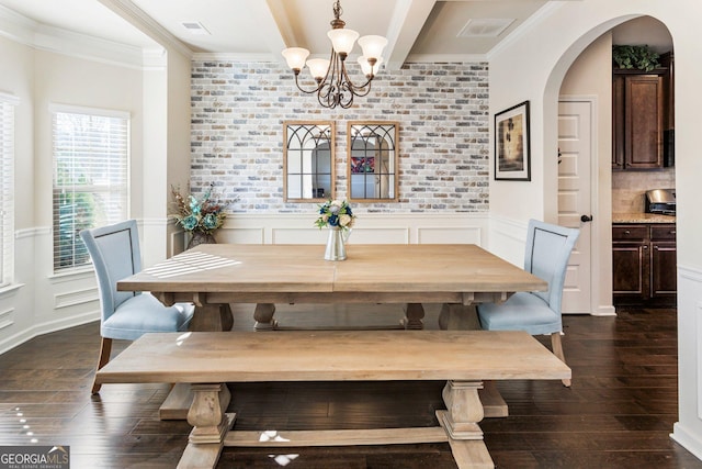 dining room featuring beamed ceiling, crown molding, dark wood-type flooring, and a chandelier