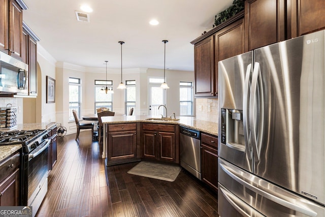 kitchen featuring sink, tasteful backsplash, dark hardwood / wood-style flooring, decorative light fixtures, and appliances with stainless steel finishes