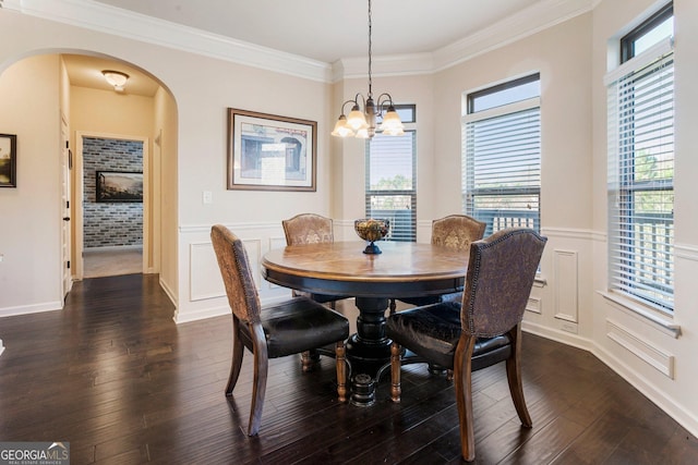 dining room featuring dark hardwood / wood-style flooring, an inviting chandelier, and ornamental molding