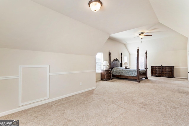 bedroom featuring ceiling fan, light colored carpet, and vaulted ceiling