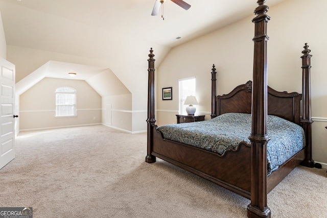 bedroom with ceiling fan, light colored carpet, and vaulted ceiling