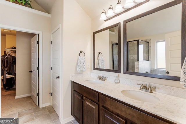 bathroom with vanity, a shower with shower door, and lofted ceiling