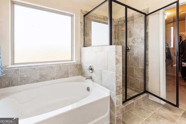 bathroom featuring plenty of natural light and independent shower and bath