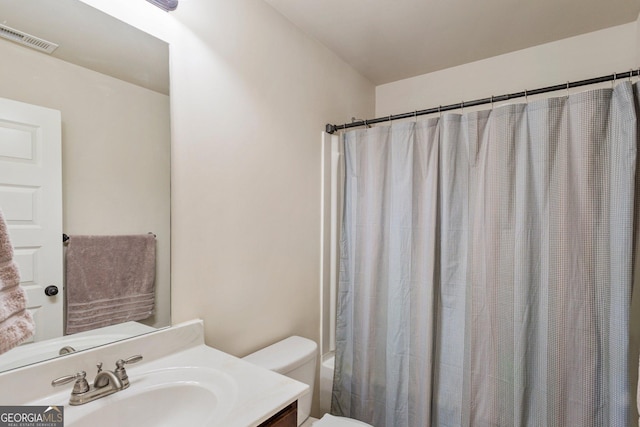 full bathroom featuring vanity, shower / bath combo, and toilet