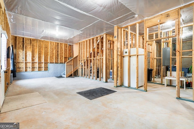 misc room with concrete flooring and electric panel