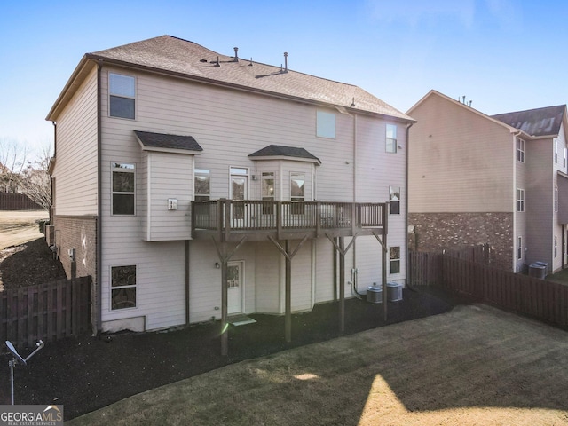 rear view of house featuring central AC unit and a yard