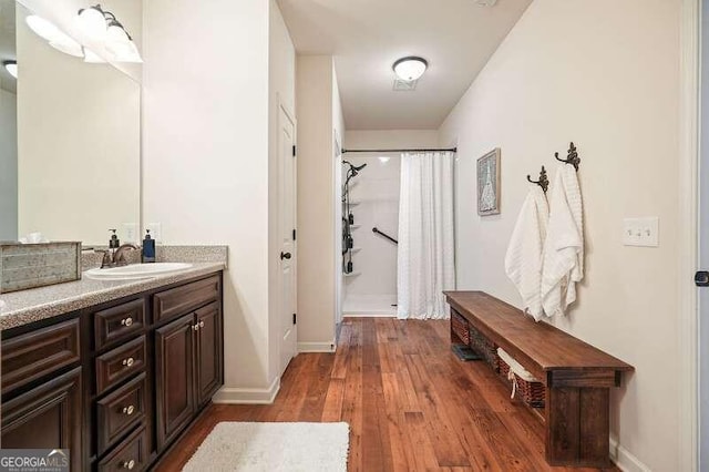 bathroom featuring walk in shower, vanity, and hardwood / wood-style flooring