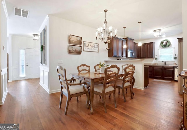 dining room featuring an inviting chandelier, dark wood-type flooring, and sink