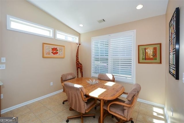 dining space featuring light tile patterned flooring and lofted ceiling