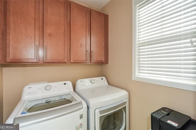 washroom featuring washing machine and dryer and cabinets