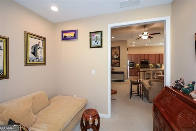 sitting room featuring light carpet and ceiling fan