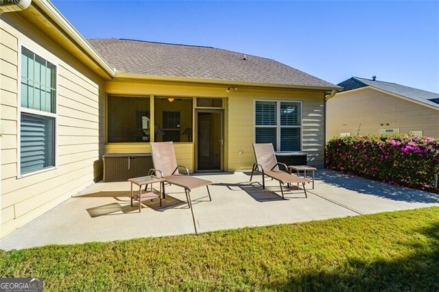 back of house with a lawn and a patio area