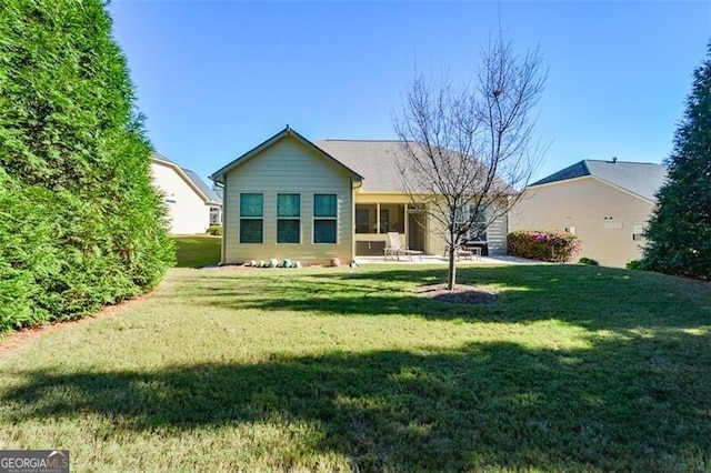 back of house with a patio area and a yard