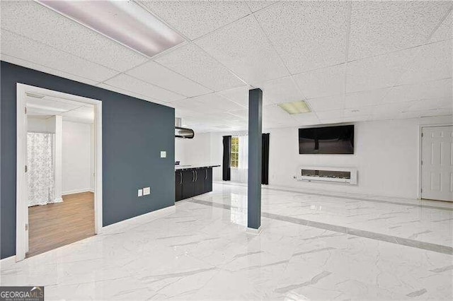 basement featuring a paneled ceiling and hardwood / wood-style flooring