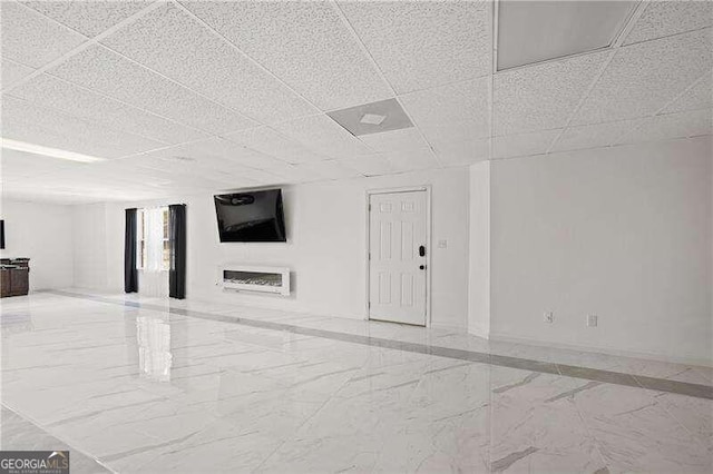 unfurnished living room with a drop ceiling