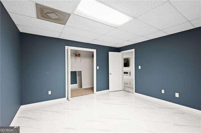 unfurnished bedroom featuring a paneled ceiling and a closet