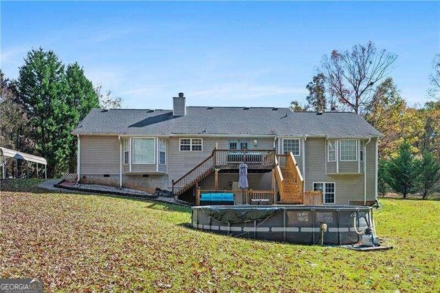 back of property with a swimming pool side deck and a lawn