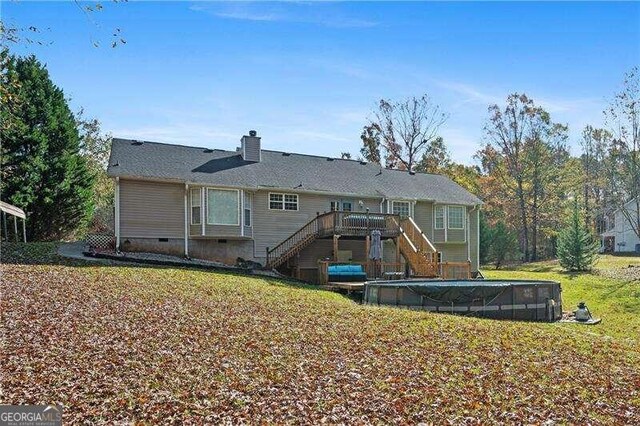 back of property featuring a lawn and a swimming pool side deck