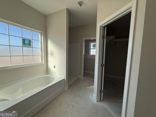 bathroom featuring a washtub and concrete flooring