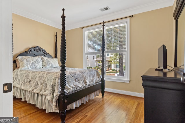 bedroom featuring ornamental molding and hardwood / wood-style flooring