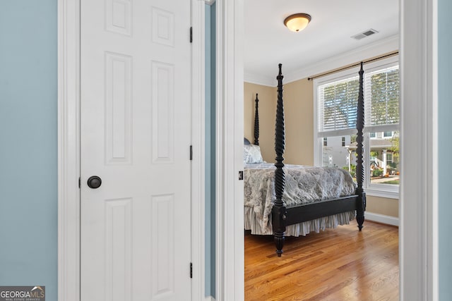 bedroom with crown molding and light hardwood / wood-style flooring