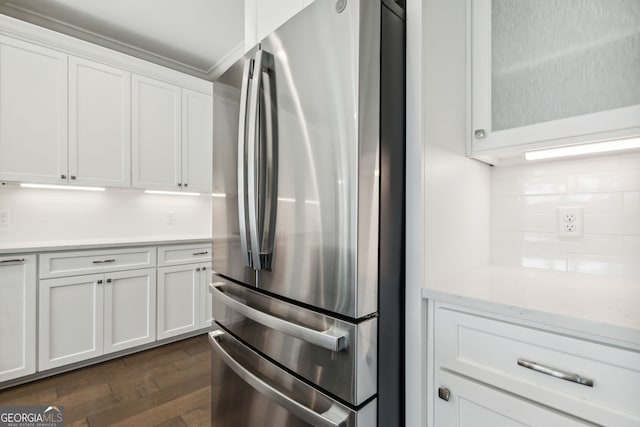 kitchen with white cabinets, stainless steel fridge, dark hardwood / wood-style flooring, and tasteful backsplash