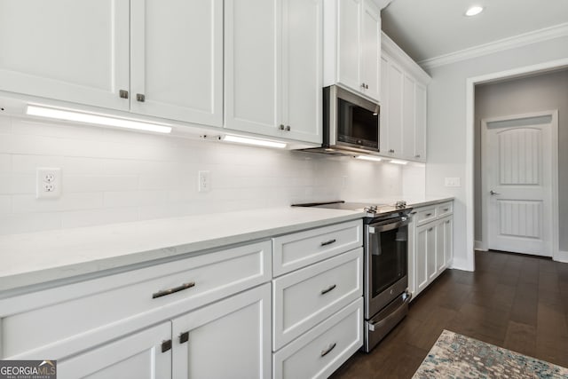 kitchen featuring light stone counters, ornamental molding, stainless steel appliances, dark wood-type flooring, and white cabinets