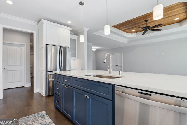 kitchen with stainless steel appliances, sink, blue cabinetry, decorative light fixtures, and white cabinetry