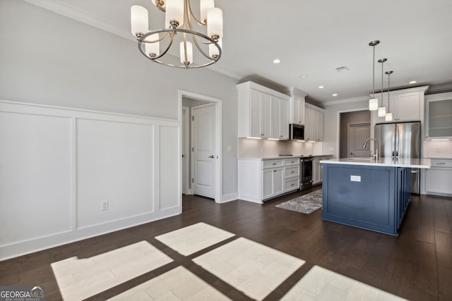 kitchen featuring pendant lighting, a kitchen island with sink, dark hardwood / wood-style flooring, white cabinetry, and a chandelier