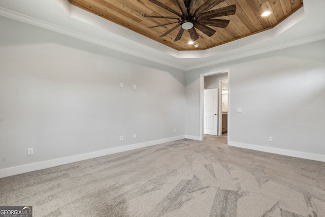 spare room featuring carpet, wooden ceiling, ceiling fan, ornamental molding, and a tray ceiling