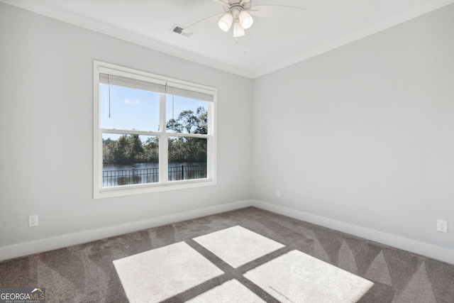 carpeted empty room with a water view, ceiling fan, and crown molding