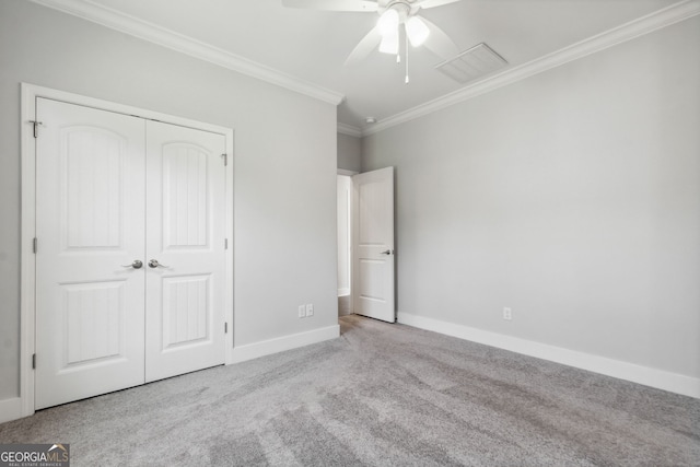 unfurnished bedroom featuring ceiling fan, crown molding, light carpet, and a closet