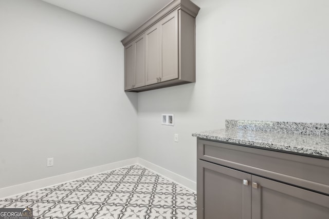 laundry area with light tile patterned flooring, cabinets, and hookup for a washing machine