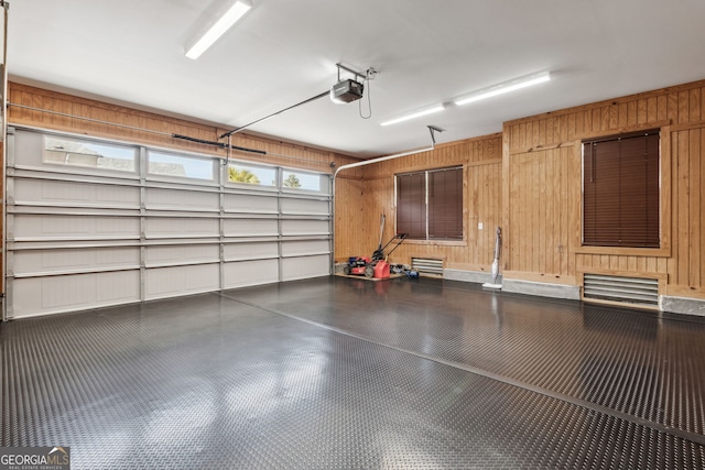 garage with wood walls and a garage door opener