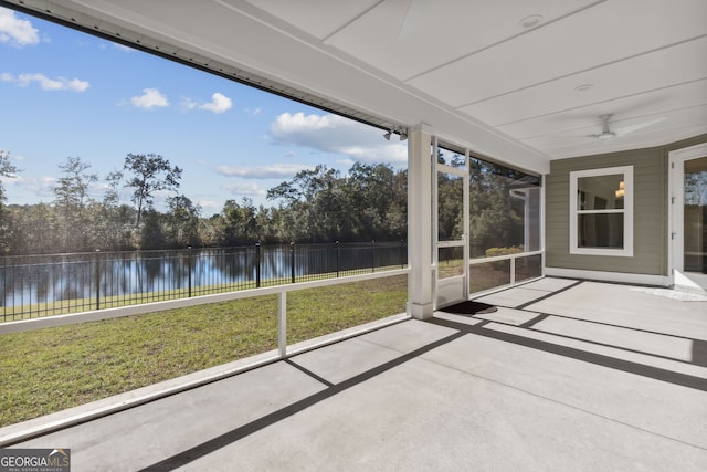 unfurnished sunroom featuring a water view and ceiling fan