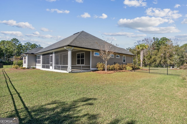 rear view of property featuring a sunroom and a lawn