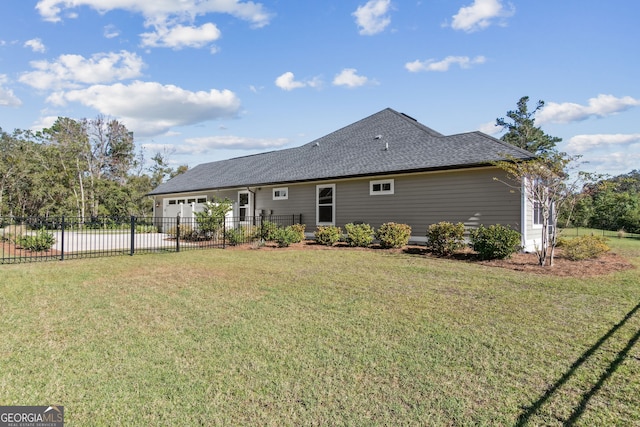 back of property featuring a yard and a garage