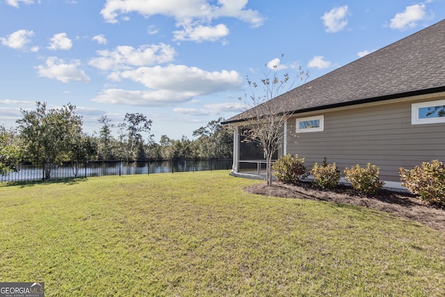 view of yard featuring a sunroom and a water view