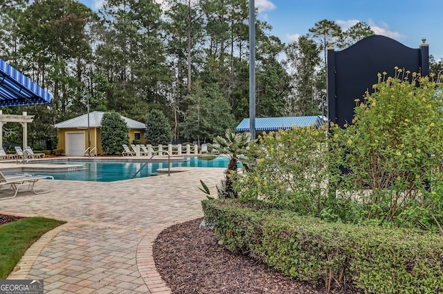 view of pool with a patio area and an outdoor structure