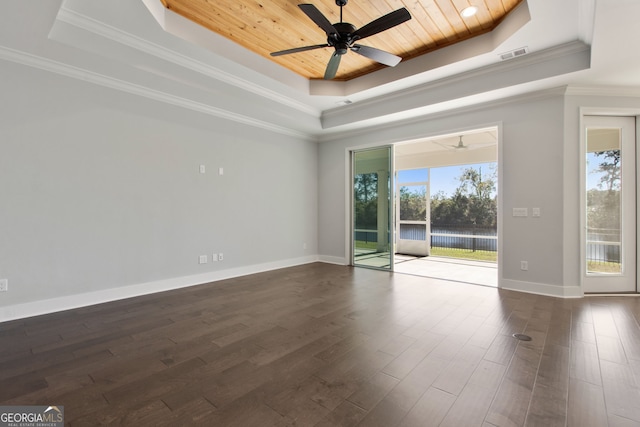 unfurnished room featuring dark hardwood / wood-style flooring, a tray ceiling, ceiling fan, and ornamental molding