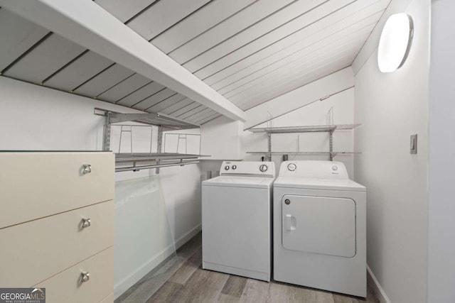 laundry area featuring hardwood / wood-style floors, wood ceiling, and washing machine and clothes dryer