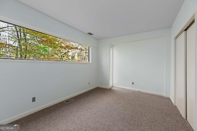 unfurnished bedroom featuring carpet flooring and a closet