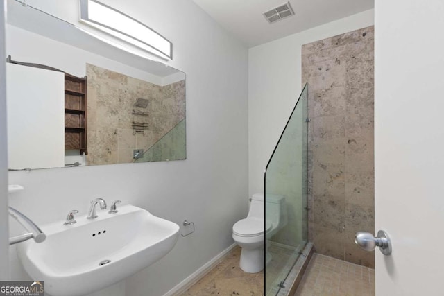 bathroom with toilet, sink, and walk in shower