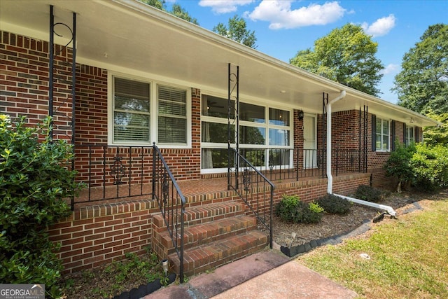 view of exterior entry featuring covered porch