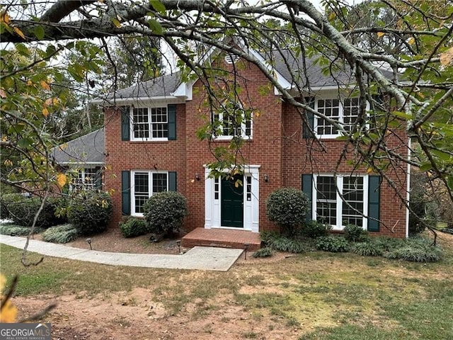 colonial home featuring a front lawn