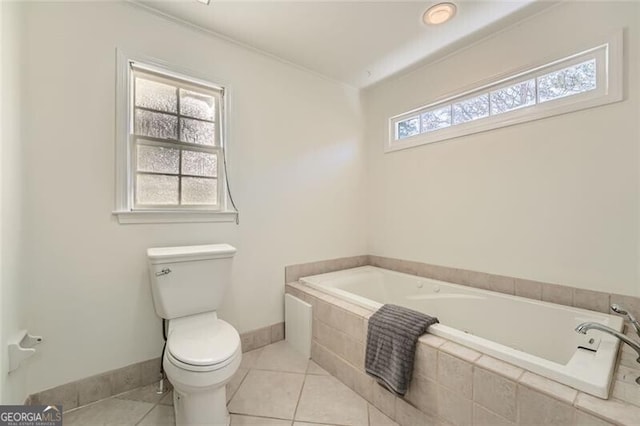 bathroom with plenty of natural light, tile patterned flooring, a relaxing tiled tub, and toilet