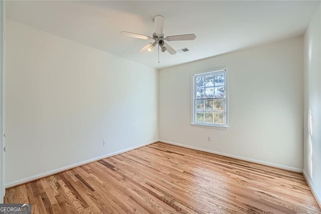 empty room with ceiling fan and light hardwood / wood-style floors